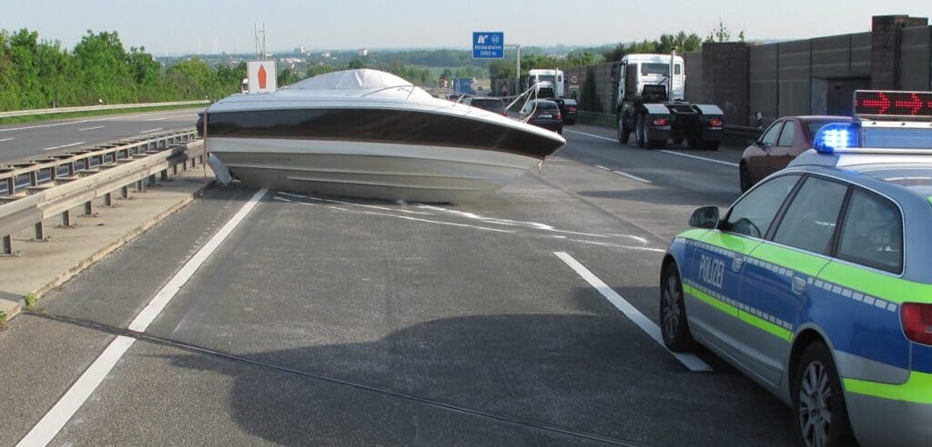 Boot blockiert Autobahn, Polizei sichert Unfallstelle.