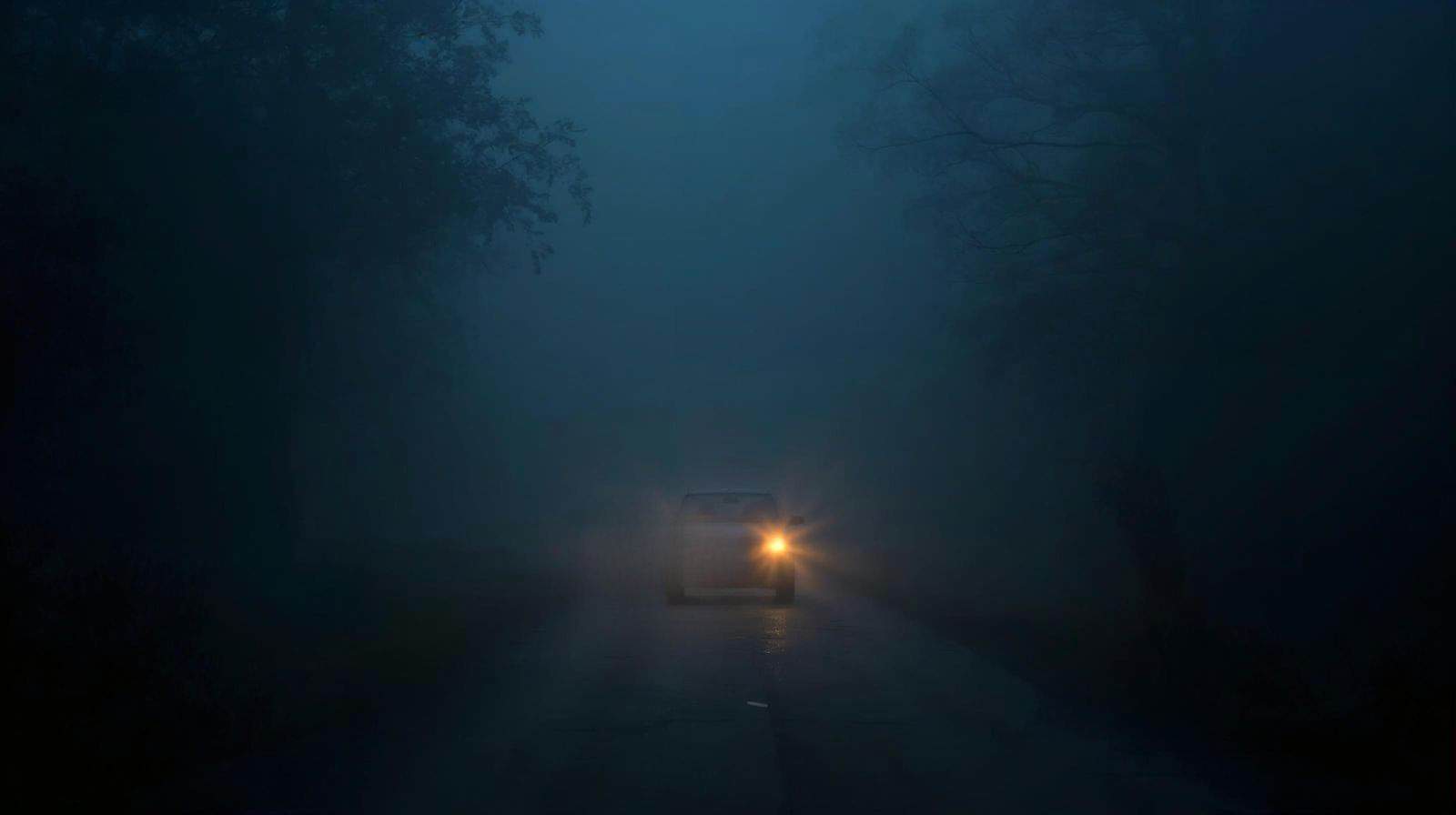 Auto mit defektem Scheinwerfer im Nebel